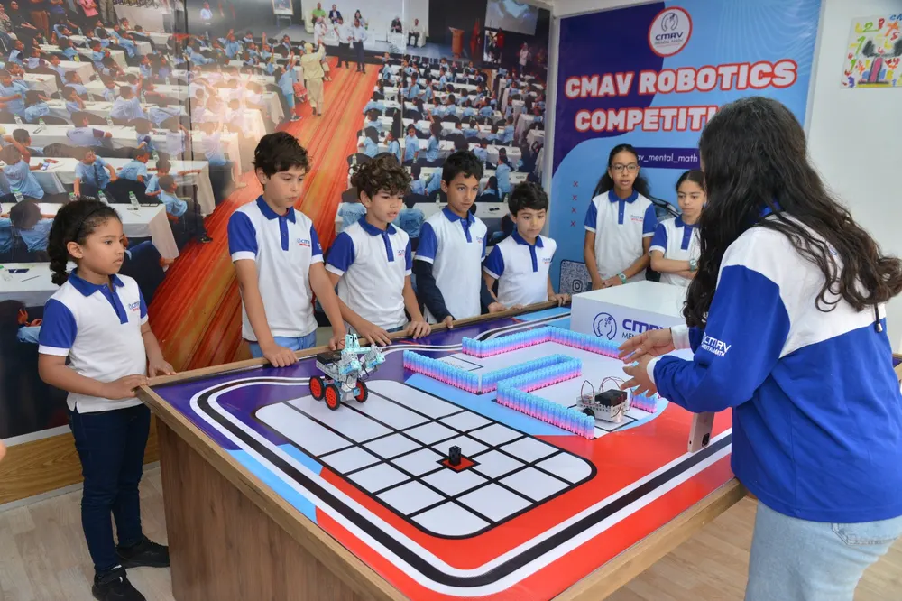 Des enfants pilotent leur robot sur un circuit lors de la compétition robotique CMAV